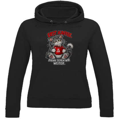 JA Erst Kaffee – Damen-Hoodie in Tiefschwarz, Vorderansicht, Frontdruck: Grimmige Katze mit roter Tasse: „Erst Kaffee. Dann sehen wir weiter.“
