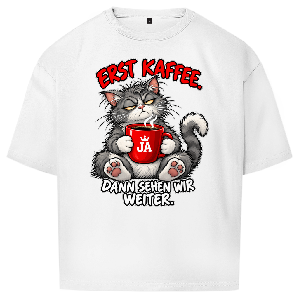 JA Erst Kaffee – Oversize-Shirt in Weiß, Vorderansicht, Frontdruck: Grimmige Katze mit roter Tasse: „Erst Kaffee. Dann sehen wir weiter.“