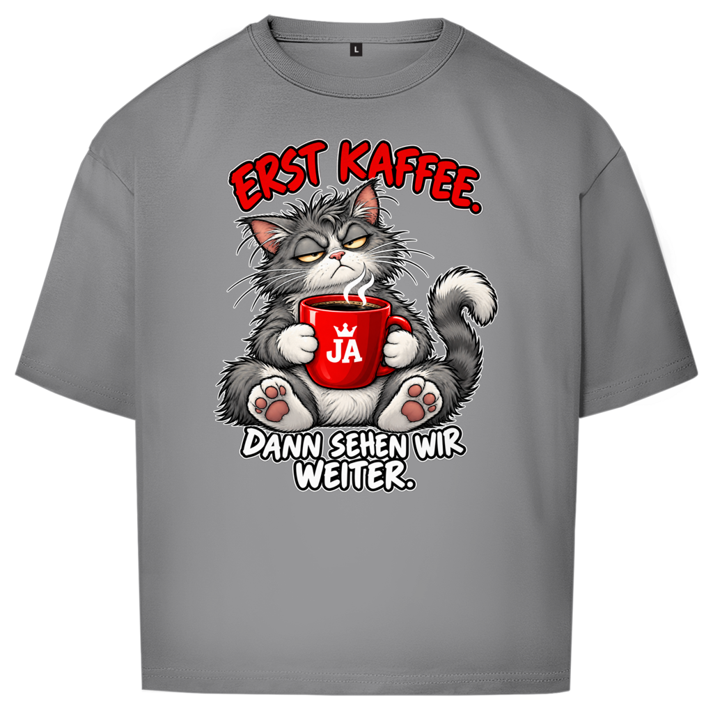 JA Erst Kaffee – Oversize-Shirt in Grau, Vorderansicht, Frontdruck: Grimmige Katze mit roter Tasse: „Erst Kaffee. Dann sehen wir weiter.“