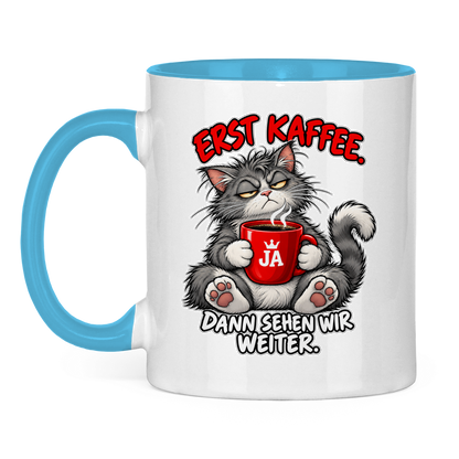 JA Erst Kaffee – Tasse in Hellblau, Vorderansicht, Aufdruck: Grimmige Katze mit roter Tasse: „Erst Kaffee. Dann sehen wir weiter.“