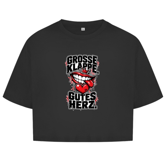 JA Große Klappe, gutes Herz – Damen-Crop-Top in Schwarz, Vorderansicht, Frontdruck: Markenspruch „Große Klappe. Gutes Herz.“ mit rotem Mund und Herz