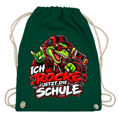 JA Schulstart Dino – Turnbeutel in Flaschengrün, Aufdruck: Dino mit Cap und Schulsachen: „Ich rocke jetzt die Schule“ zur Einschulung