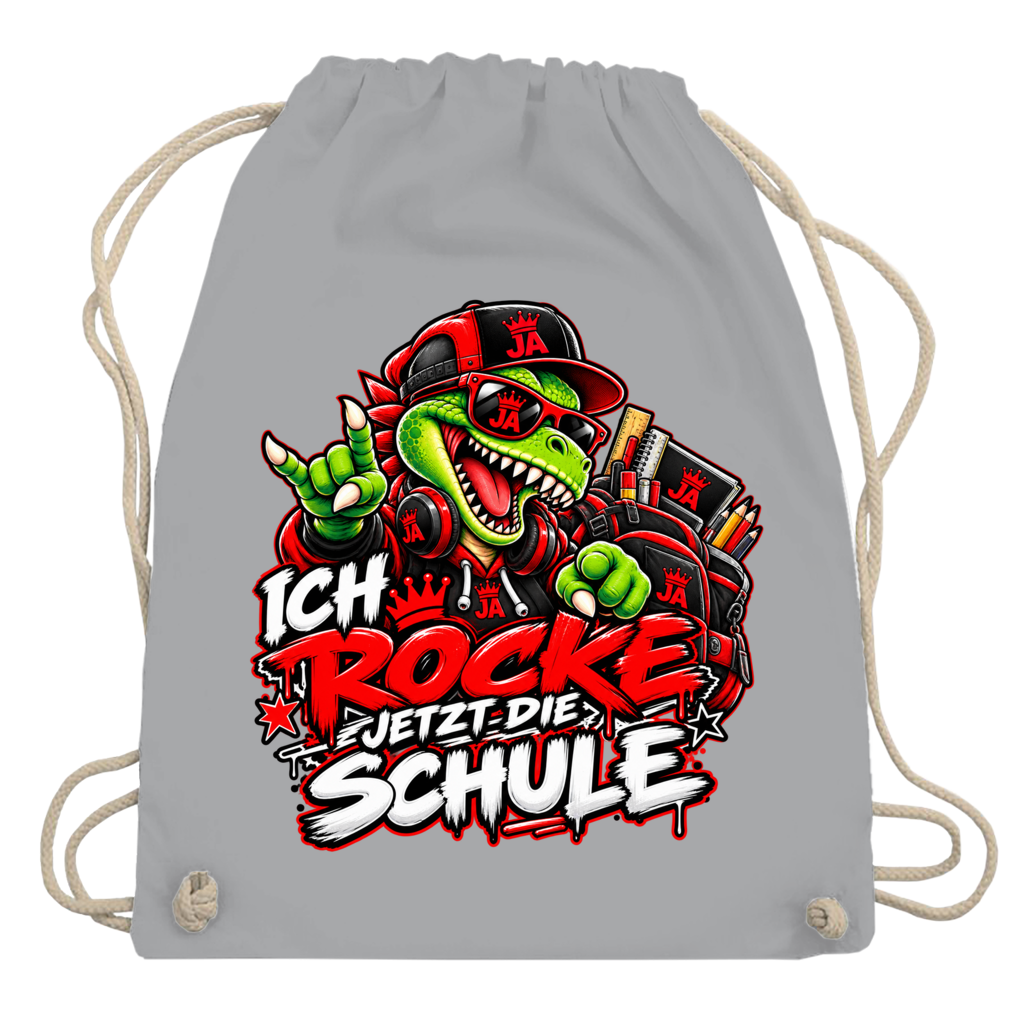 JA Schulstart Dino – Turnbeutel in Hellgrau, Aufdruck: Dino mit Cap und Schulsachen: „Ich rocke jetzt die Schule“ zur Einschulung
