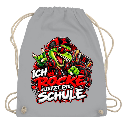 JA Schulstart Dino – Turnbeutel in Hellgrau, Aufdruck: Dino mit Cap und Schulsachen: „Ich rocke jetzt die Schule“ zur Einschulung