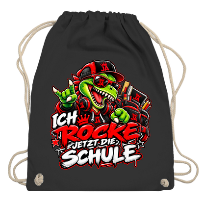 JA Schulstart Dino – Turnbeutel in Schwarz, Aufdruck: Dino mit Cap und Schulsachen: „Ich rocke jetzt die Schule“ zur Einschulung