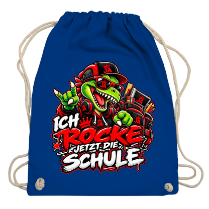 JA Schulstart Dino – Turnbeutel in Königsblau, Aufdruck: Dino mit Cap und Schulsachen: „Ich rocke jetzt die Schule“ zur Einschulung