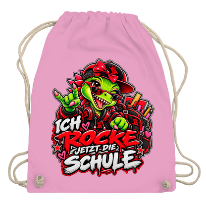 JA Schulstart Dino Mädchen – Turnbeutel in Rosa, Aufdruck: Dino-Mädchen mit Schulsachen: „Ich rocke jetzt die Schule“ zur Einschulung