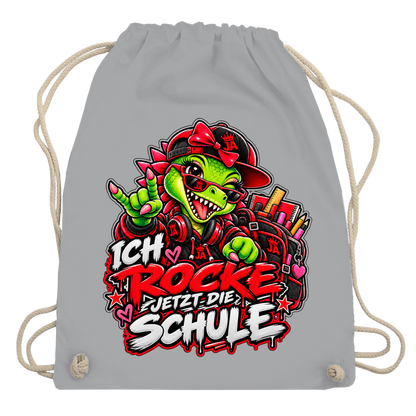 JA Schulstart Dino Mädchen – Turnbeutel in Hellgrau, Aufdruck: Dino-Mädchen mit Schulsachen: „Ich rocke jetzt die Schule“ zur Einschulung