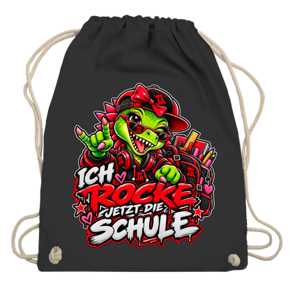 JA Schulstart Dino Mädchen – Turnbeutel in Schwarz, Aufdruck: Dino-Mädchen mit Schulsachen: „Ich rocke jetzt die Schule“ zur Einschulung