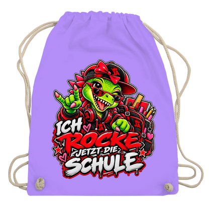JA Schulstart Dino Mädchen – Turnbeutel in Lavendel, Aufdruck: Dino-Mädchen mit Schulsachen: „Ich rocke jetzt die Schule“ zur Einschulung