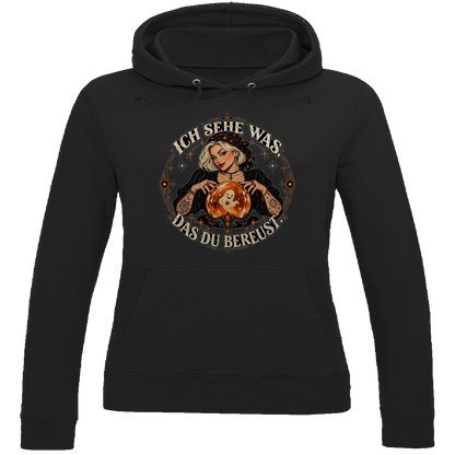 JA Orakel – Damen-Hoodie in Tiefschwarz, Vorderansicht, Frontdruck: Wahrsagerin mit Kristallkugel und Spruch „Ich sehe was, das du bereust“