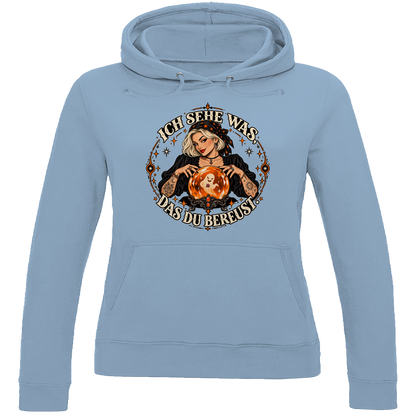 JA Orakel – Damen-Hoodie in Himmelblau, Vorderansicht, Frontdruck: Wahrsagerin mit Kristallkugel und Spruch „Ich sehe was, das du bereust“